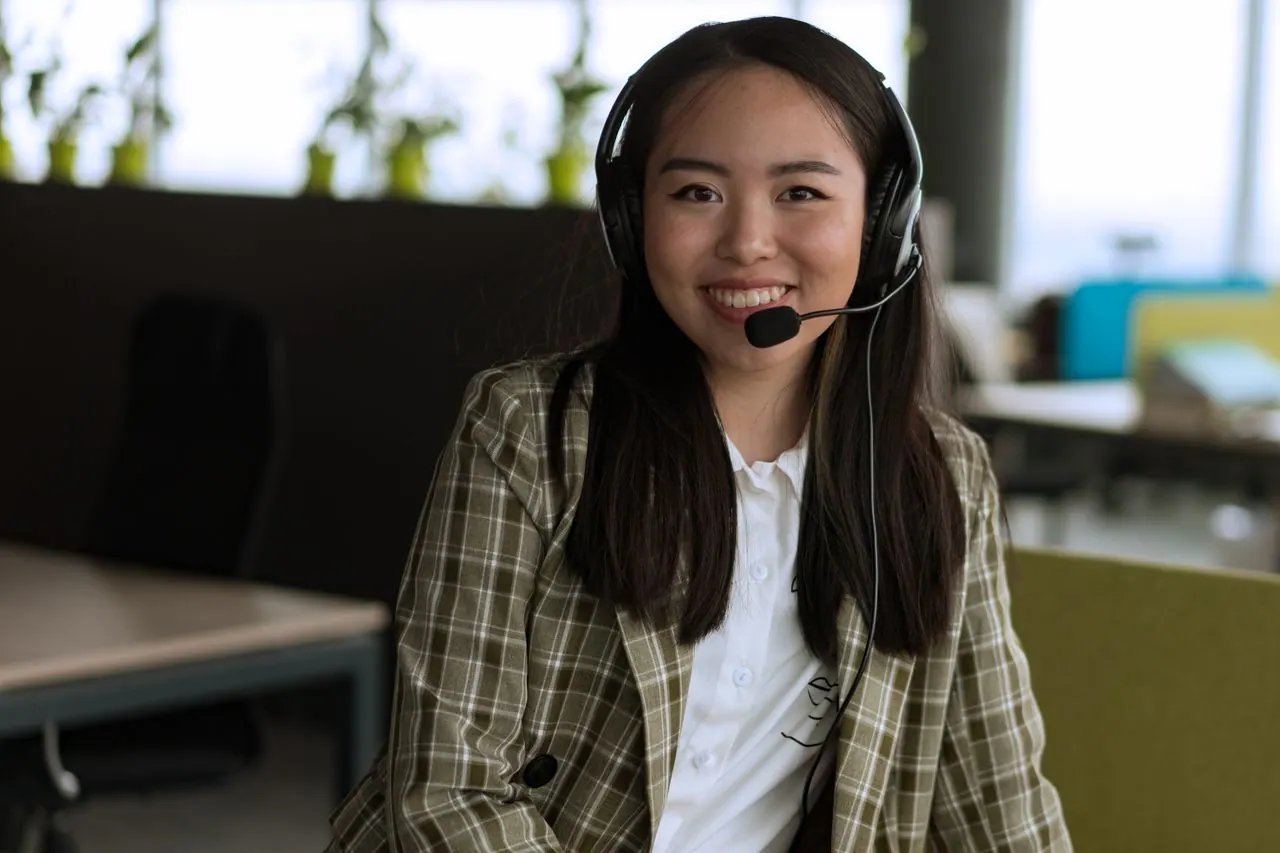 Smiling customer support professional wearing a headset in a welcoming office